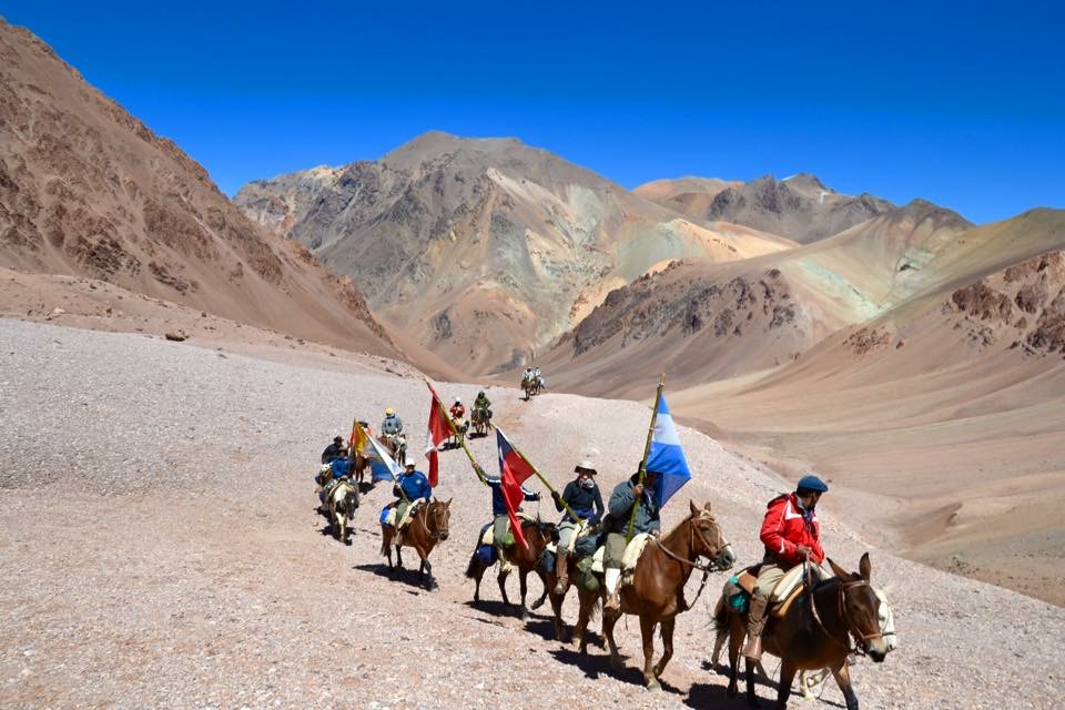Jinetes con banderas en camino montañoso