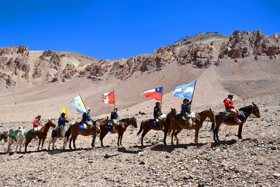Formación de jinetes con banderas internacionales