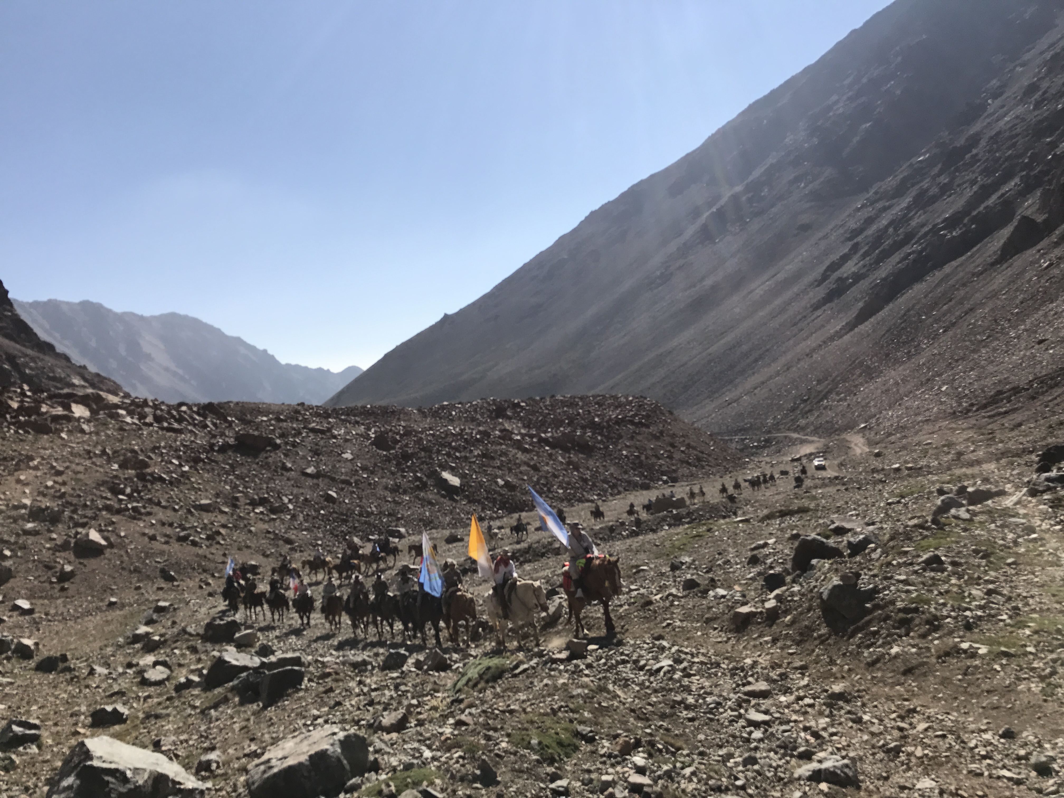 Expedicionarios con banderas en terreno rocoso volcánico
